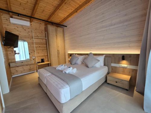 a bedroom with a bed with two towels on it at Nalu Beach Villas in Lukovë