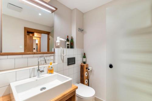 a bathroom with a sink and a toilet and a shower at Wein- und Klimahotel Bergfriedel in Bühlertal