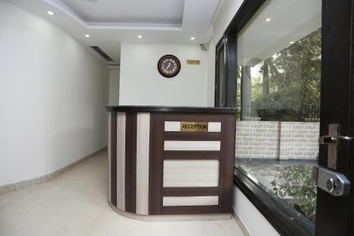 a door in a room with a clock on the wall at Hotel O Vagmi Residency - Grand in Gurgaon