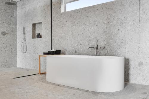 a white tub in a bathroom with a shower at Clouds Estate in Stellenbosch