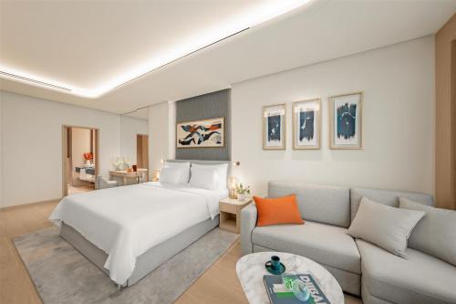 a hotel room with a bed and a couch at The Meydan Hotel Dubai in Dubai