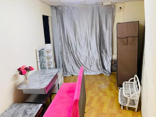a living room with a pink couch and a table at Chill Door Homestay in Ấp Long Ðại