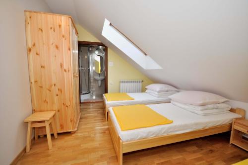 two twin beds in a room with a attic at DW Dunajecki Gościniec in Biały Dunajec