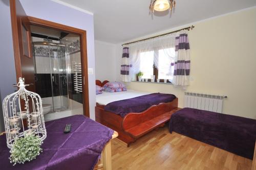 a bedroom with a bed and a couch and a window at DW Dunajecki Gościniec in Biały Dunajec
