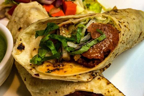 Un taco con carne y verduras en un plato blanco. en Hotel O Uchhash, en kolkata