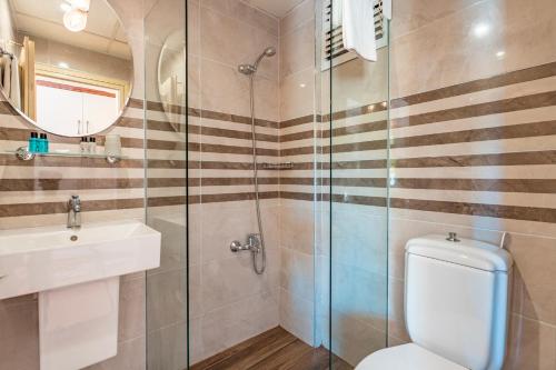 a bathroom with a toilet and a glass shower at Tu Casa Gelidonya Hotel in Kemer