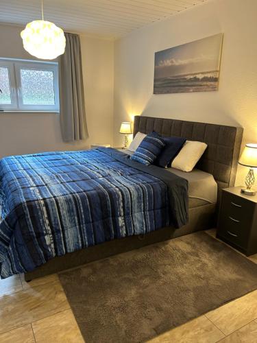 a bedroom with a bed with a blue blanket at Rodenbach 1 BR Apartment in Rodenbach