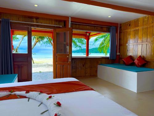 a bedroom with two beds and a view of the ocean at SoonNoeng Resort in Koh Rong Sanloem