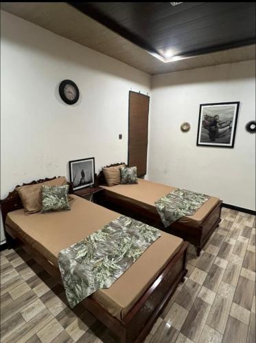 a room with two beds and a clock on the wall at Hunter's Cottage in Ban