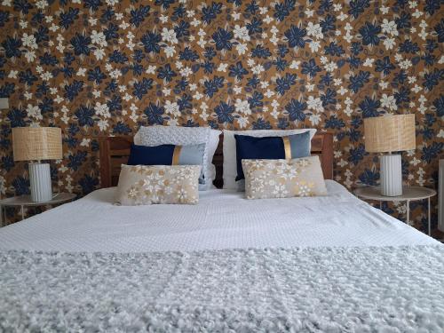 a bedroom with a white bed with two lamps at Les mésanges bleu in Malmedy