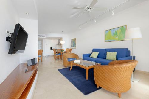 a living room with a blue couch and a tv at Anfi del Mar 1 in La Playa de Arguineguín