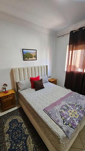 Un dormitorio con una cama grande con una almohada roja. en Agadir city break, en Agadir