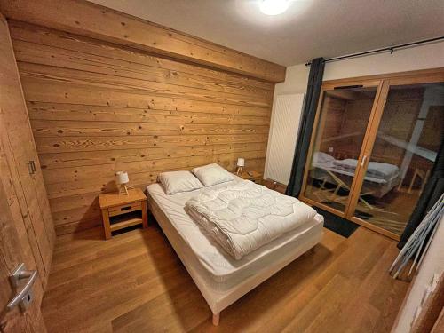 a bedroom with a bed in a wooden wall at Appartement aux Saisies, 62m², 7 pers, 3 étoiles, Parking inclus - FR-1-293-411 in Les Saisies