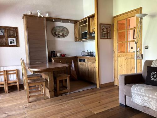 a living room with a table and a kitchen at Charmant appartement 3 pièces au centre, balcon sud - FR-1-464-253 in Pralognan-la-Vanoise