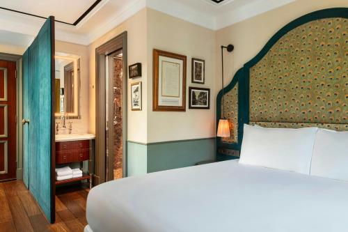 a bedroom with a large bed and a bathroom at Maxwell Reserve Singapore, Autograph Collection in Singapore