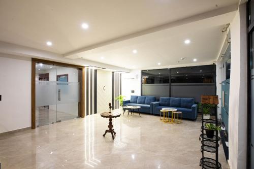 a living room with a blue couch and a table at Aarchh Regency Noida in Noida
