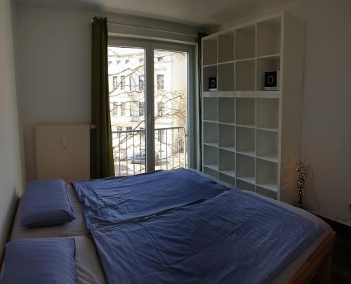 a bedroom with a blue bed and a window at Modernes Apartment Stadtfeld Ost Panoramafenster in Magdeburg