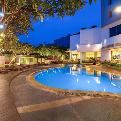 a swimming pool in a courtyard of a building at night at Cityloog Hotel Tebet Jakarta in Jakarta