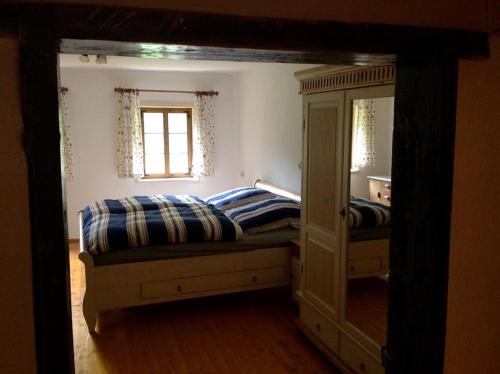 a bedroom with two beds and a mirror at Grillnhäusl in Wegscheid