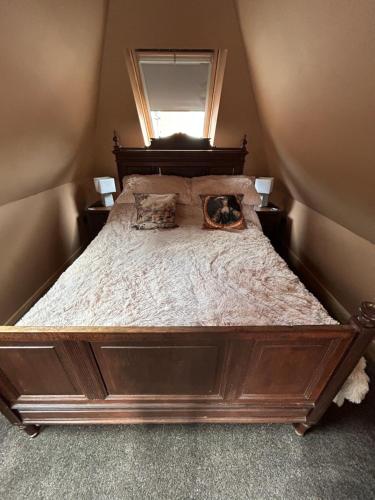 a large wooden bed with two pillows on it at Keepers Lodge in Nottingham