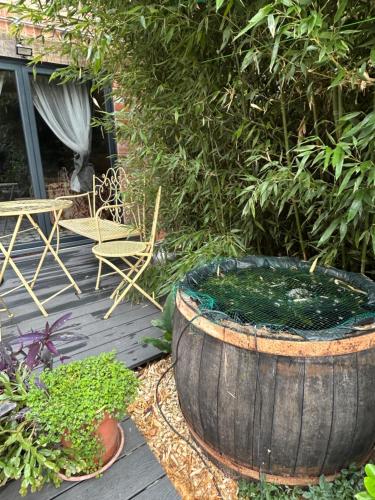 a large barrel sitting on a deck with a table and chairs at Keepers Lodge in Nottingham