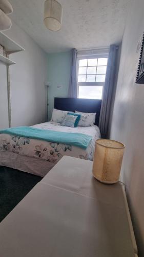 a small bedroom with a bed and a window at Haven Retreat at Hillrise in Herne Bay