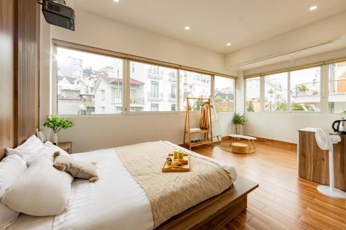 a bedroom with a large bed and large windows at The Morris Boutique Hotel 2 - O'TEL in Da Lat