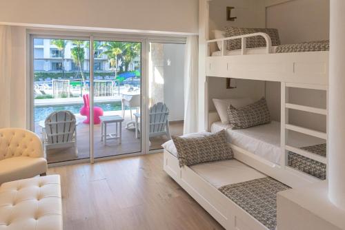a bedroom with a bunk bed and a living room with a balcony at Princess Family Club Bavaro - All Inclusive in Punta Cana