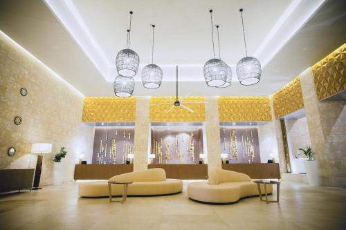 a lobby with two chairs and tables and lights at Grand Bavaro Princess - All Inclusive in Punta Cana