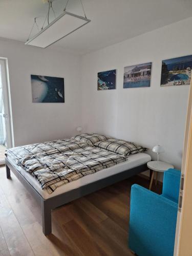 a bedroom with a bed and a blue chair at Apartment Altmünster mit Traunsteinblick in Altmünster