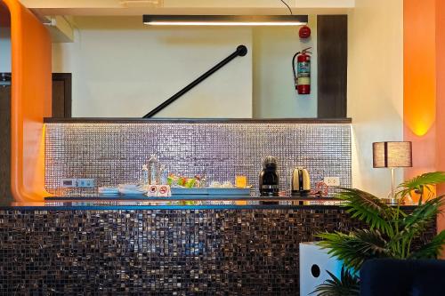 a bar in a restaurant with a tile wall at CRIMSON SERIES - Boutique Hotel & Wine Bar in Chiang Mai