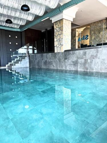 a swimming pool with blue water in a building at Milmari apartman SAN-28 in Kopaonik