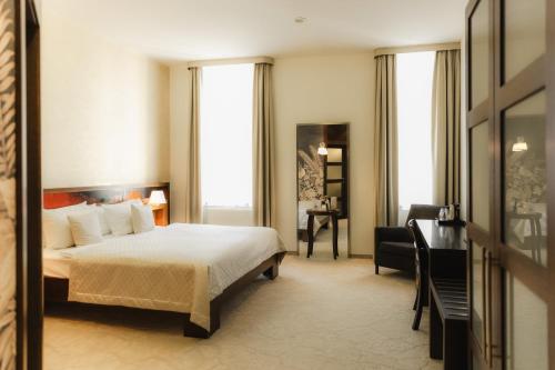 a hotel room with a bed and a desk at Boutique Hotel Dubná Skala in Žilina