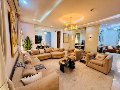 a large living room with couches and a dining room at Geodetic Apartment in Lagos