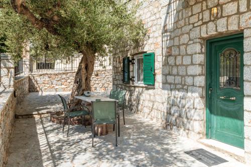 a table and chairs next to a building with a tree at Peaceful Refuge In Mani 1 in Khalíkia