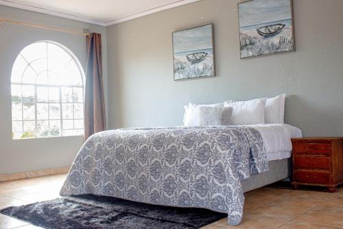 a bedroom with a large bed and a window at Inn on Lichfield Lane in Harare