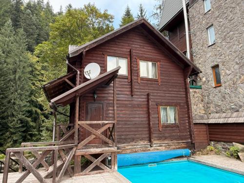 a house with a pool in front of a building at Готель Пацьорка in Kremintsi
