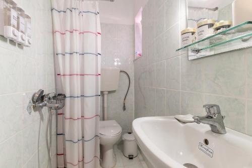 a bathroom with a sink toilet and a shower curtain at Peaceful Refuge In Mani 2 in Kótronas