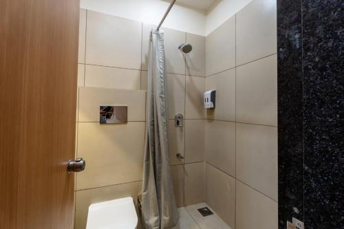 a bathroom with a shower and a toilet in it at Prarambh By Siara in Nadiad