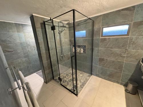 a shower with a glass door in a bathroom at Villa Talassa in Le Morne