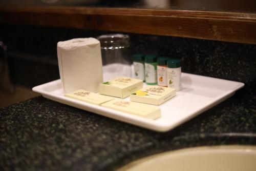 a white plate with toiletries on a bathroom counter at Hotel Willow Banks Shimla in Shimla