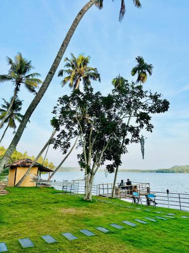 two people sitting on a bench next to the water at Lakeshore Retreats Varkala in Varkala