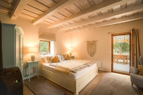 a bedroom with a bed and a table and a window at D9 Cottage in Csesznek