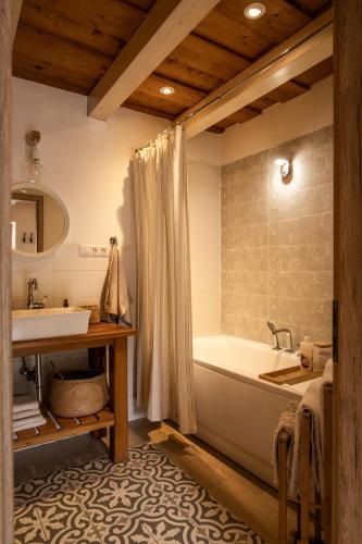 a bathroom with a tub and a sink at D9 Cottage in Csesznek