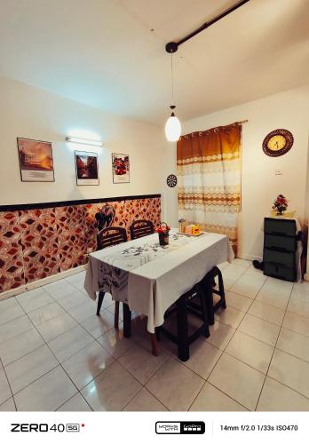 a dining room with a white table with chairs at Homestay D'Lapang near KLIA in Sepang