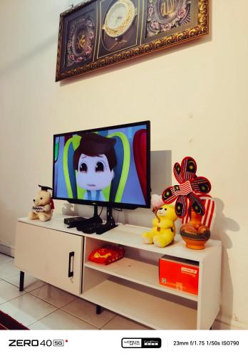 a flat screen tv sitting on top of a tv stand at Homestay D'Lapang near KLIA in Sepang