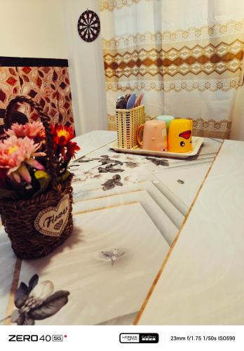 a table with a basket of flowers on it at Homestay D'Lapang near KLIA in Sepang