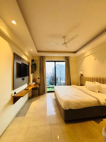 a bedroom with a large bed and a television at Zoneout Stays Omaxe Hazratganj in Lucknow