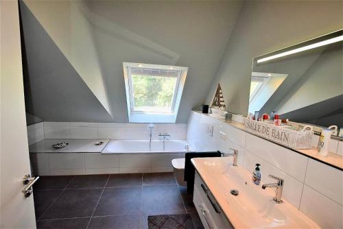 a bathroom with a bath tub and a sink at Seesucht-Hohwacht - Grosse Ferienwohnung im Beachhouse-Stil, 2 Balkone, 2 SZ und nur 300m zum Strand in Hohwacht