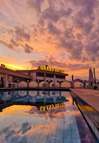 a hotel with a pool in front of a sunset at Grand Hotel Europa in Isernia